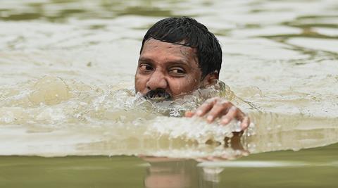 Chennai: A man moves to safe place from flooded Kotturpuram during heavy rains in Chennai on Wednesday. PTI Photo by R Senthil Kumar(PTI12_2_2015_000148A)