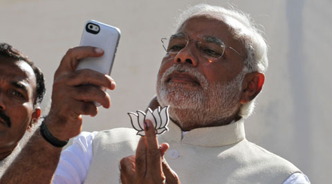 Narendra Modi displayed his party’s symbol lotus, after having cast his vote. (AP Photo)