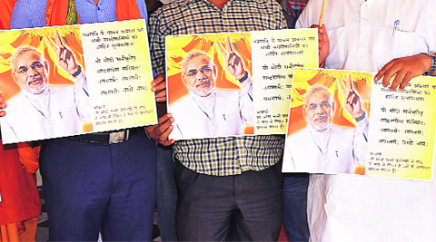 BJP workers hold the poster with ‘modified’ Durga Saptshati shloka in Varanasi. (IE Photo: Ravi Prakash)