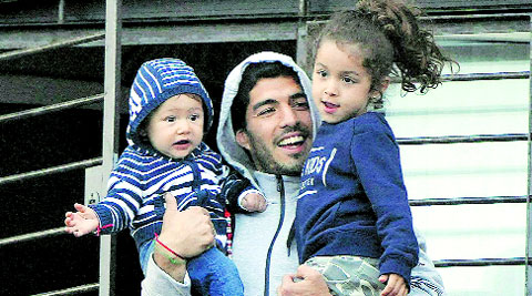 Suarez at home with his children. The Uruguayan told FIFA’s disciplinary panel that he did not deliberately bite Chiellini at the World Cup. (Source: AP)