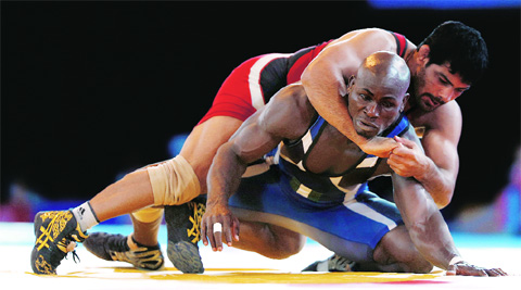 Sushil Kumar wrestles with Melvin Bibo of Nigeria in the semifinal of the men’s 74 kg freestyle event. This was the only bout in which Sushil was stretched somewhat on his way to a second Commonwealth Games gold. (Top right) Amit Kumar with his gold medal in the 57kg category. Source: Reuters/PTI/AP