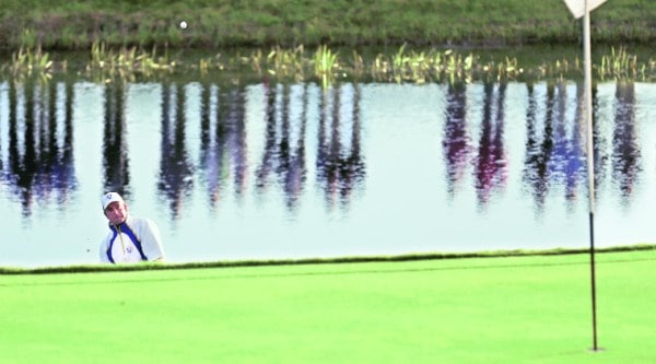Henrik Stenson stands in the lake to play a shot onto the 2nd green on the second day. Source: REUTERS