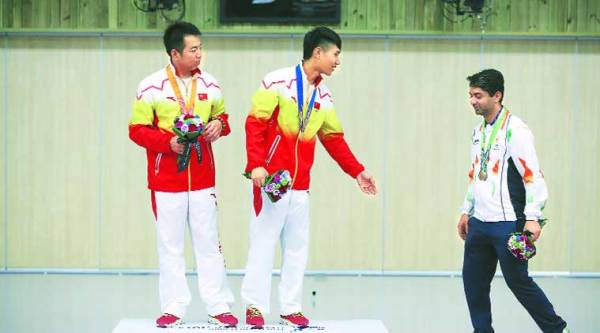 (From left) Silver medalist Cao Yifei and gold medalist Yang Haoran of China ask Abhinav Bindra to join them for a photo session during the Men’s 10m Air Rifle victory ceremony. ( Source: AP )