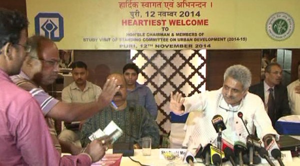 Angry journalists in press meet at Puri waving the envelope at the organisers after they found Rs 200 slipped in their press kits. (Source: IE photo)