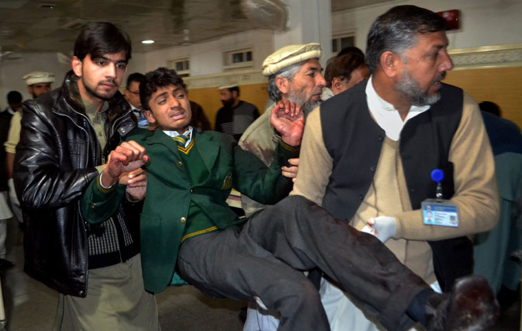 Pakistani volunteers carry a student injured in the shootout at a school under attack by Taliban gunmen, at a local hospital in Peshawar, Pakistan,Tuesday, Dec. 16, 2014. Taliban gunmen stormed a military school in the northwestern Pakistani city, killing and wounding dozens, officials said, in the latest militant violence to hit the already troubled region. (AP Photo/Mohammad Sajjad)