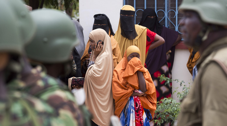 Women look across as Kenya Defence Forces (KDF) soldiers arrive at a hospital to escort the bodies of the attackers to be put on public view, in Garissa, Kenya Saturday, April 4, 2015. (Source: AP)
