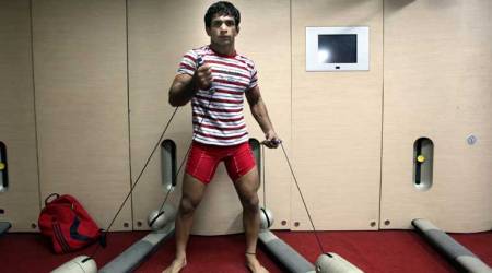 Wrestler Amit Kumar Dahiya climbs down to take a step up