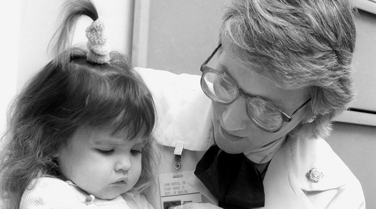 In this June 1988 photo provided by Children's Hospital of Wisconsin, Lynn Bartos, pediatric nurse for Children's Hospital of Wisconsin Gastroenterology Clinic, holds Nicole Frye. The nurse and family were featured on the cover of the hospital's nursing magazine in 1988 for a story about long term care. (Source: AP)