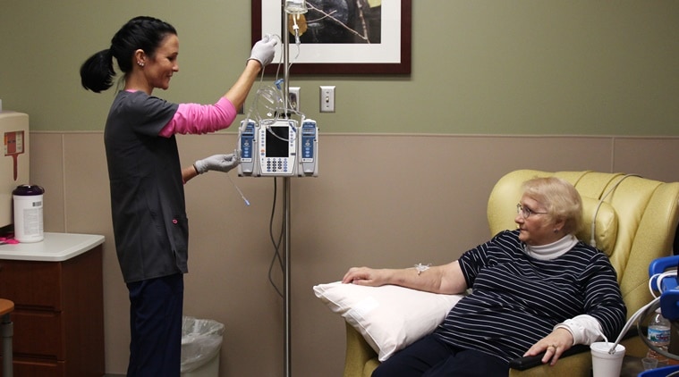 In this Dec. 22, 2015 photo, nurse Nicole Krahn, left, gets rheumatoid arthritis medication ready for semi-retired nurse Lynn Bartos at Froedtert & the Medical College of Wisconsin in Wauwatosa, Wisconsin. (Source: AP)