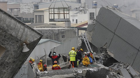 Rescue teams continue to search for the missing in a collapsed building, after an early morning earthquake in Tainan, Taiwan, Saturday, Feb. 6, 2016. A 6.4-magnitude earthquake struck southern Taiwan early Saturday, toppling at least one high-rise residential building and trapping people inside. (AP Photo/Wally Santana)