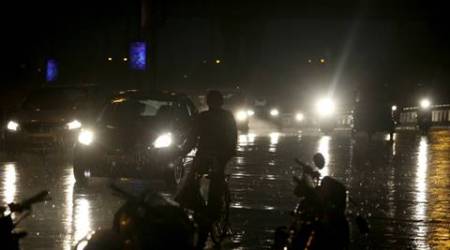 A Vehicle and people move during rain in New Delhi on Monday. Express Photo By Amit Mehra 23 May 2016
