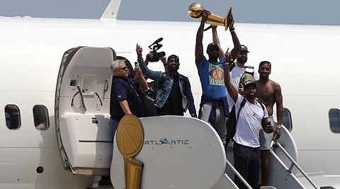 Off the plane but still sky-high, LeBron James brings  title home