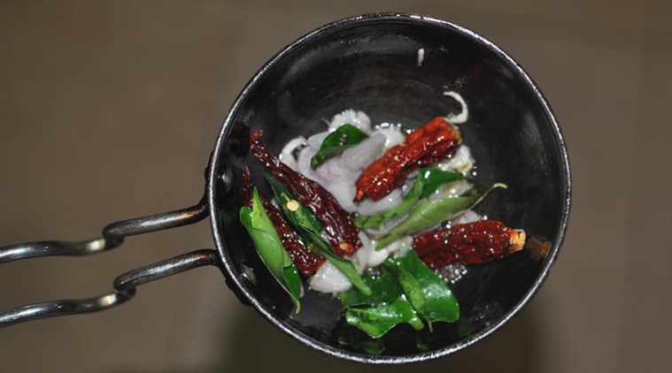 The tempering for the curry, which includes mustard seeds, curry leaves, shallots and red chillies, is added at the end to the curry. (Source: mareenasrecipecollections.com)