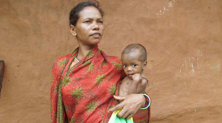 Sukei Pradhan, 36, a mother of seven, with her sixth child. She has already lost two children; (below) the long trek to Nagada village, which a few officials only recently made after reports emerged of the deaths. Debabrata Mohanty