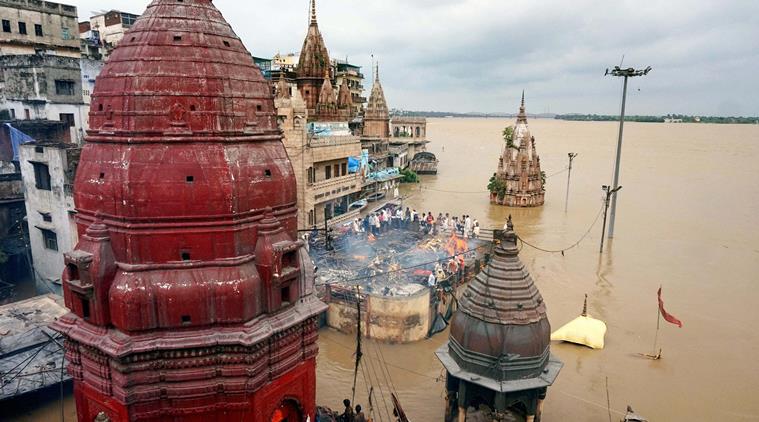 Cremations being performed on the roof a building as the famous Manikarnika Ghat is seen flooded in Varanasi on Monday. PTI Photo (PTI8_22_2016_000289B)