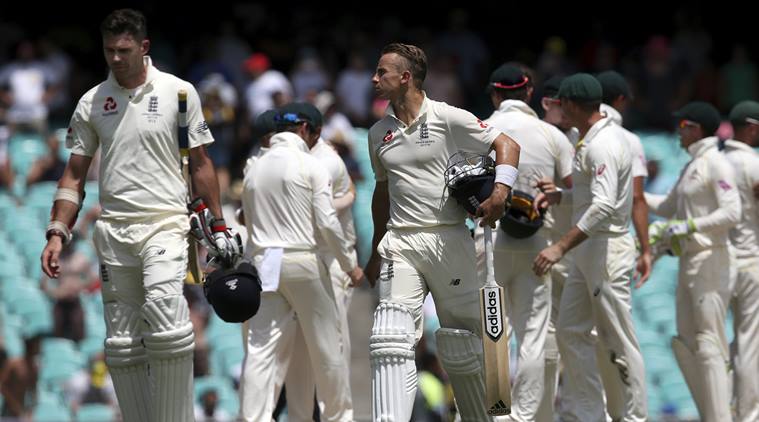 England's James Anderson and Tom Curran walk as Australia celebrate Ashes win
