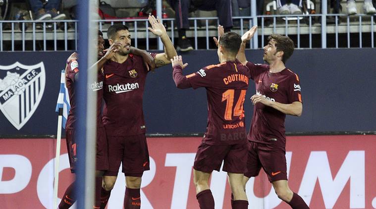 Barcelona players celebrate a goal against Malaga