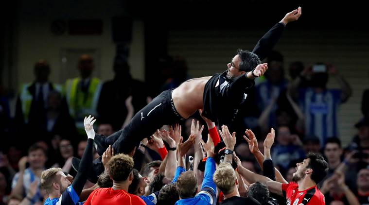 Huddersfield Town players throw manager David Wagner in the air as they celebrate staying in the Premier League after the match against Chelsea