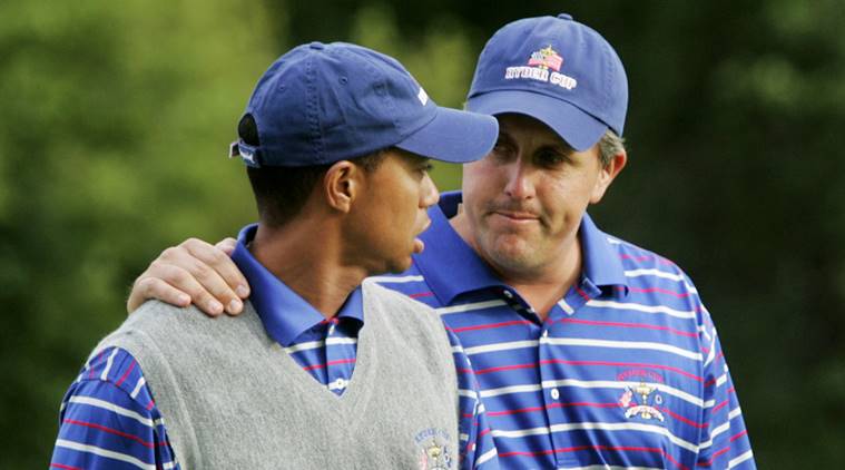 US golfer Phil Mickelson puts his arm around partner Tiger Woods as they walk off the 18th green after they lost to Europeans Darren Clarke and Lee Westwood on the final hole of their foursomes match at the 35th Ryder Cup at Oakland Hills Country Club in Bloomfield Township.
