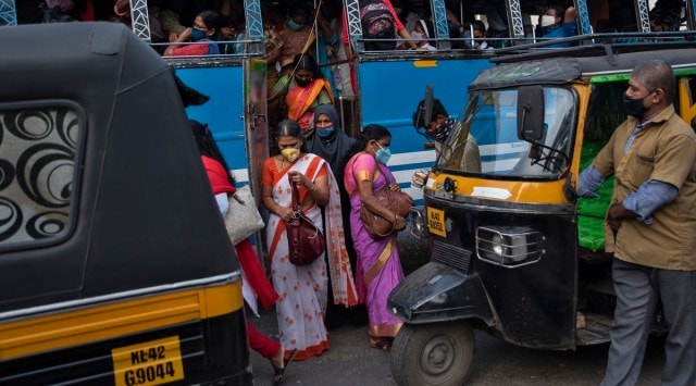 People wearing masks as a precaution against the coronavirus alight from a bus in Kochi (AP Photo/R S Iyer)