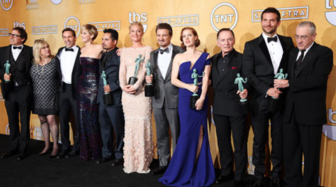From left, David O. Russell, Colleen Camp, Alessandro Nivola, Jennifer Lawrence, Michael Pena, Elisabeth Rohm, Jeremy Renner, Amy Adams, Paul Herman, Bradley Cooper and Robert De Niro pose in the press room with the award for outstanding performance by a cast in a motion picture for “American Hustle” at the 20th annual Screen Actors Guild Awards. (AP) 