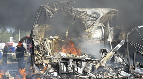 Firefighters put out the fire of a wrecked bus that collided head on with a truck near San Martin, Argentina. (AP)