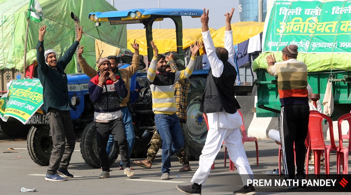 Farmers celebrate after the SC hearing, at the Ghazipur border Monday. (Express Photo: Prem Nath Pandey)