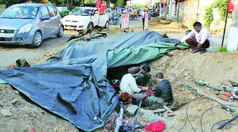 BSNL employees repair the damaged cables on Pakhowal Road in Ludhiana on Friday. (IE photo: Gurmeet Singh)