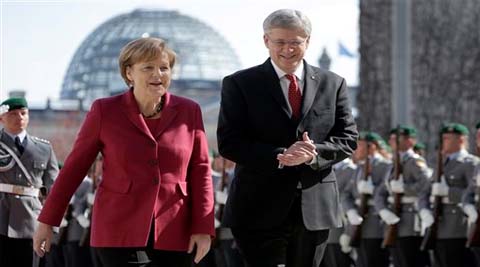 German Chancellor Angela Merkel welcomes the Prime Minister of Canada Stephen Harper in Berlin on Thursday. (AP)