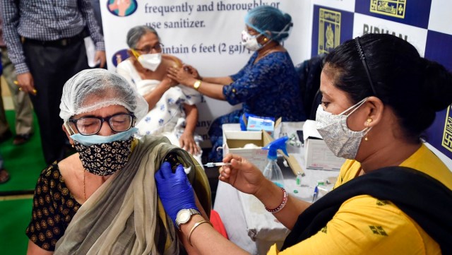 A health worker administers a dose of the Covid-19 vaccine to a woman, at a vaccination centre in Kolkata. (PTI Photo)