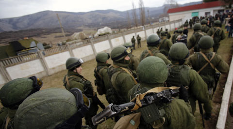 Unidentified armed men patrol around a Ukraine infantry base in Perevalne, Ukraine. (AP)