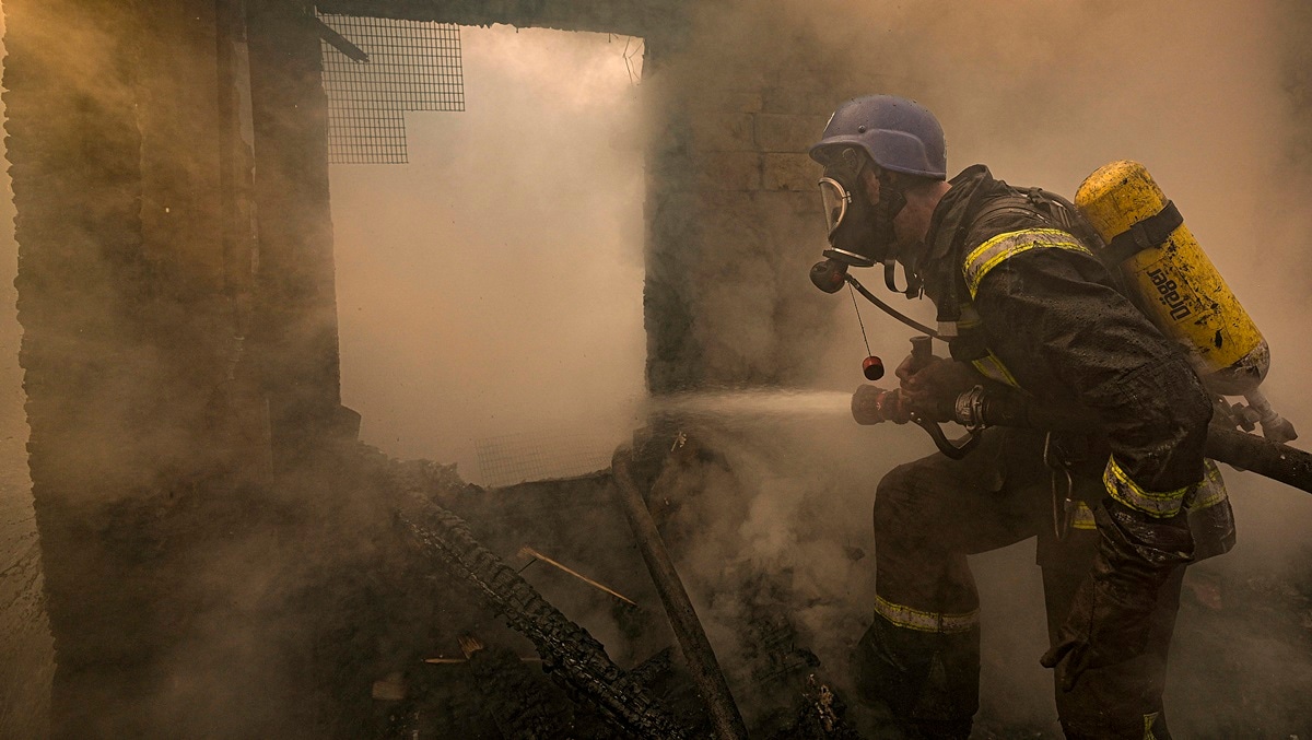 A Ukrainian firefighter sprays water inside a house destroyed by shelling, in Kyiv, Ukraine (AP photo)