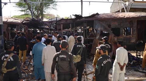Pakistani police commandos stand near the wreckage of a passenger train in Sibi, Pakistan. (AP)