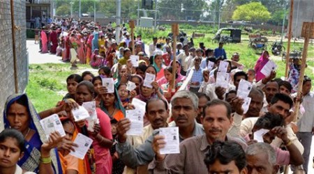 People wait in long queues to cast their votes at a polling station for Lok Sabha elections.