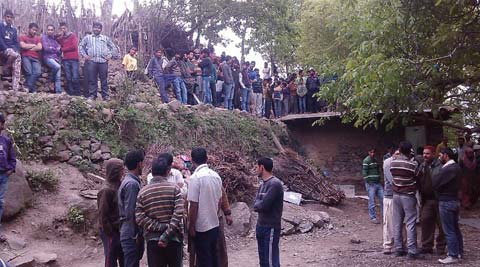 Policemen and local villagers waiting for the arrival of wildlife officials with a tranquilizer gun and trap at village Nowgam near Banihal on Monday evening.