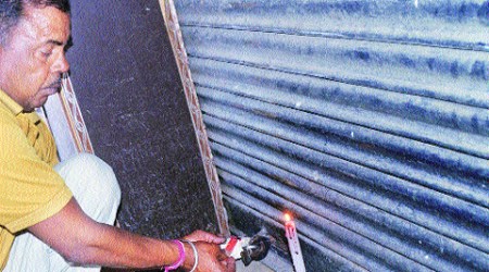 Officials of Estate Office seal a booth at Krishna Market in Sector 41 on Thursday. (Kamleshwar Singh)