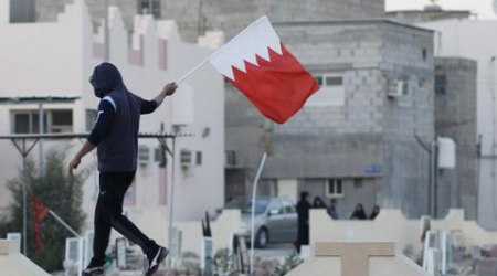 A protestor carries the Bahrain flag. (Source: Reuters)