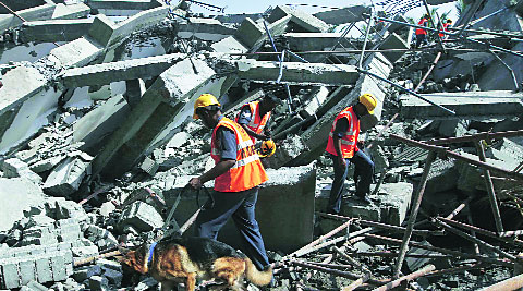 Rescue workers search for survivors in the rubble of the collapsed building, Sunday.