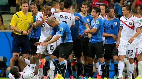 Uruguay's Maxi Pereira reaches out to Costa Rica's Joel Campbell, left, after he fouled him. (Source: AP photo)
