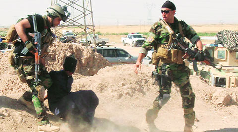 Kurdish personnel capture a suspected militant belonging to ISIL on outskirts of Kirkuk Monday. ( Source: Reuters )