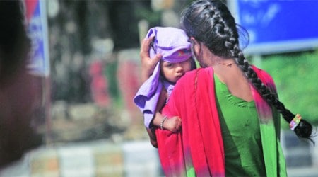 A woman shields her child from the sun and heat on Friday.     ( Express Photo: Oinam Anand)
