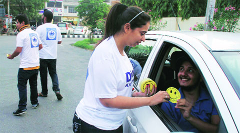 NGO members distribute smileys to commuters in Ludhiana on Tuesday.  Gurmeet Singh