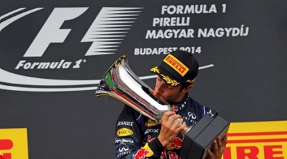 Lewis Hamilton kisses his trophy on the podium