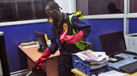 An employee of the Monrovia City Corporation sprays disinfectant inside a government building in a bid to prevent the spread of the deadly Ebola virus, in the city of Monrovia, Liberia. (Source: AP)