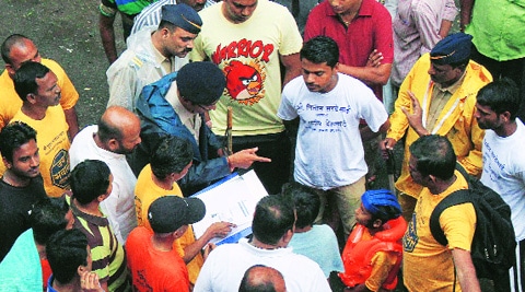 A policeman enquires with a child Govinda about his age even as a mandal member shows him his birth certificate. (Source: Express photo by Pradeep Kochrekar)