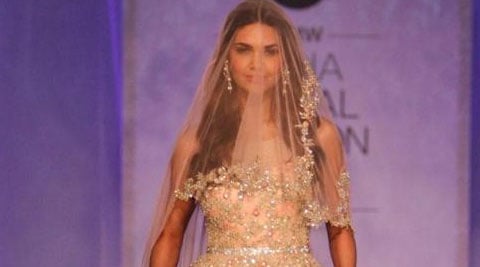 Esha Gupta turned a contemporary Christian bride on the ramp. She completed the look of the bride in a flowy gown and a veil covering her head. (Source: Twitter)   
