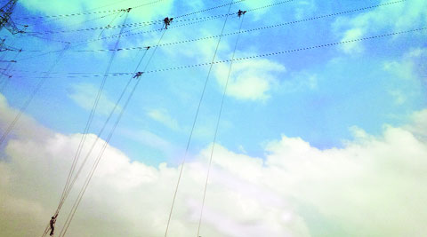At home several feet above the ground, workers fix high-tension cables for a new power sub-station in Gurgaon. (Express photo by Raj Kamal Jha)