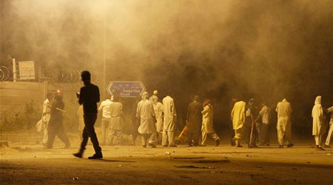 Pakistani protesters gather at a road while police fire tear gas shell to disperse them during clashes in Islamabad, Pakistan, Sunday, Aug. 31, 2014. ( Source: AP )