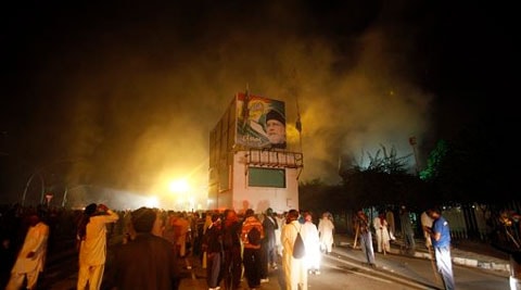 Pakistani protesters gather around a container with portrait of Pakistan's anti-government cleric Tahir-ul-Qadri as police fire tear gas shell to disperse them during clashes in Islamabad. ( Source: AP )