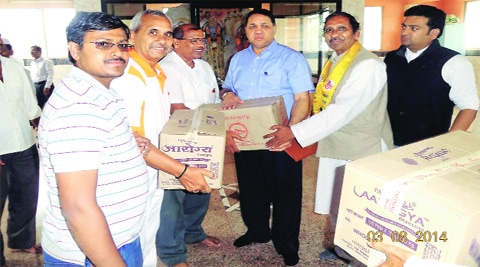 Unable to reach landslide-hit Malin village, Patanjali Yog Samiti volunteers handed over relief aid to State Assembly Speaker Dilip Walse-Patil (third from right). ( Source: Express photo by Pavan Khengre )